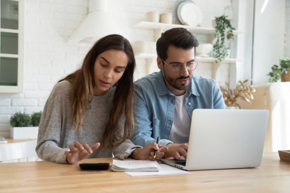 Couple calculating bills at their kitchen table.